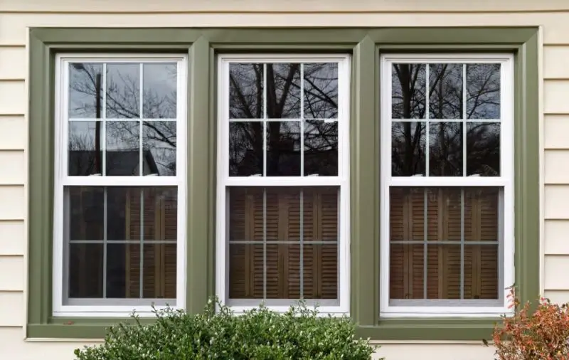 A window with brown trim designed to reduce air leakage and improve energy efficiency in Delaware