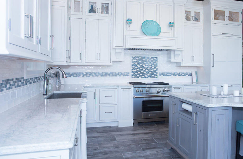 Bright kitchen with white cabinets, blue tile backsplash, and modern appliances in Delaware