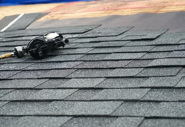 Nail gun on asphalt shingle roof