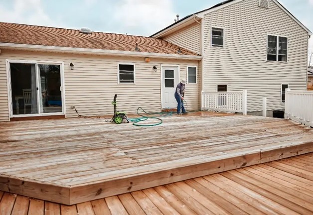 Woman cleaning wooden deck in Maryland home